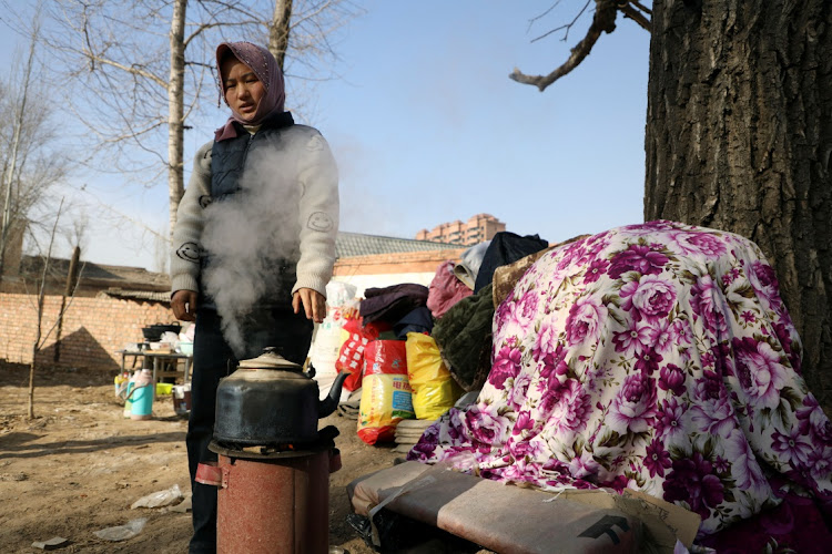 Zhou Habai, 24, stands next to a kettle on a stove at Sibuzi village following the earthquake in Jishishan county, Gansu province, China December on 21 2023. Picture: XIAOYU YIN/REUTERS