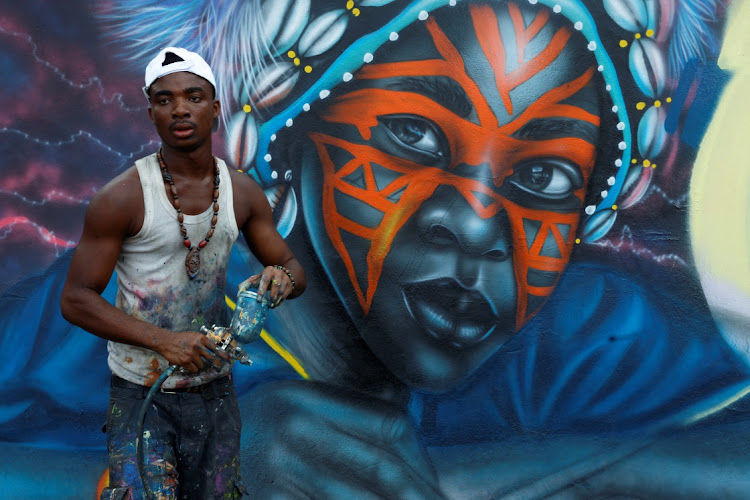 Angelo Guessan, 22, a young Ivorian student in art and also a street artist, works on a mural depicting the face of a traditional dancer, during the first edition of Graff Ivoire, in Abidjan, Ivory Coast November 13, 2024.