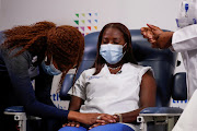 Mavis Knox prays next to nurse Sandra Lindsay, before Lindsay receives the second dose of a Pfizer coronavirus disease (COVID-19) vaccine, at Long Island Jewish Medical Center in the Queens borough of New York City, U.S. on January 4, 2021.