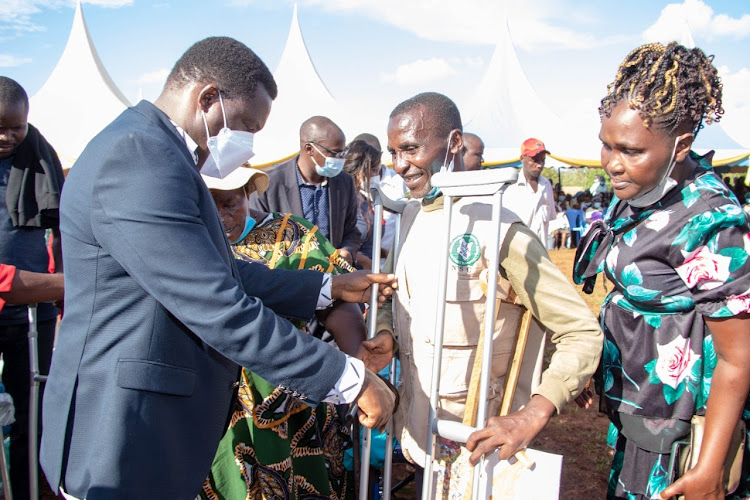 Tharaka Nithi Governor Muthomi Njuki engages PWDs at Kathwana market on Monday.