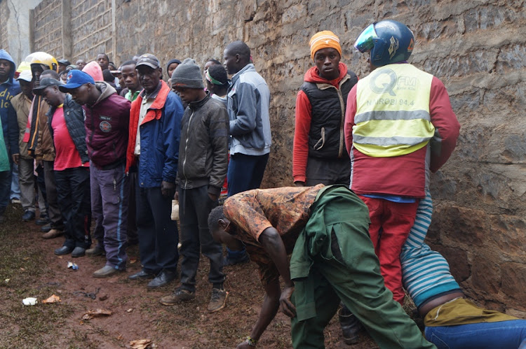 Residents at the scene where the body of Moses Maina was found in Limuru town on Tuesday morning