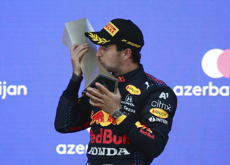 Red Bull's Sergio Perez kisses a trophy as he celebrates on the podium after winning the race