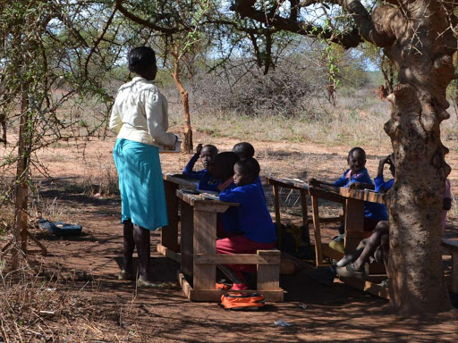 Jennifer Saisa, teaches some of the class one pupils in Olmkonge primary school in Kajiado county.