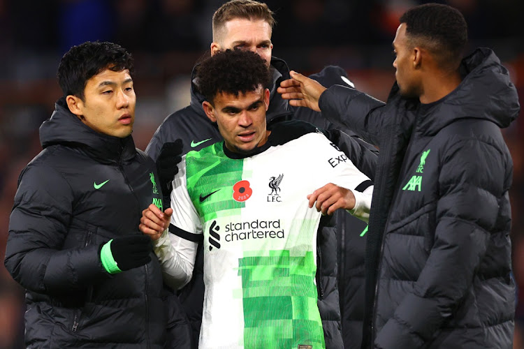 Liverpool forward Luis Diaz is embraced by teammates at full-time after the Premier League match against Luton Town at Kenilworth Road on November 5 2023 in Luton, England.