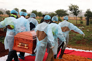 Members from a funeral parlour during the burial of a Covid-19 victim at Olifantsvlei cemetery, south of Johannesburg, during the peak of the pandemic. 