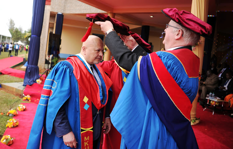 Mount Kenya University Chancellor prof John Struthers (right) confer chief prosecutor at the International Criminal Court Karim Khan (left) when the university honoured the prosecutor during 23rd graduation ceremony held at Graduation pavilion in Thika on August 4, 2023.