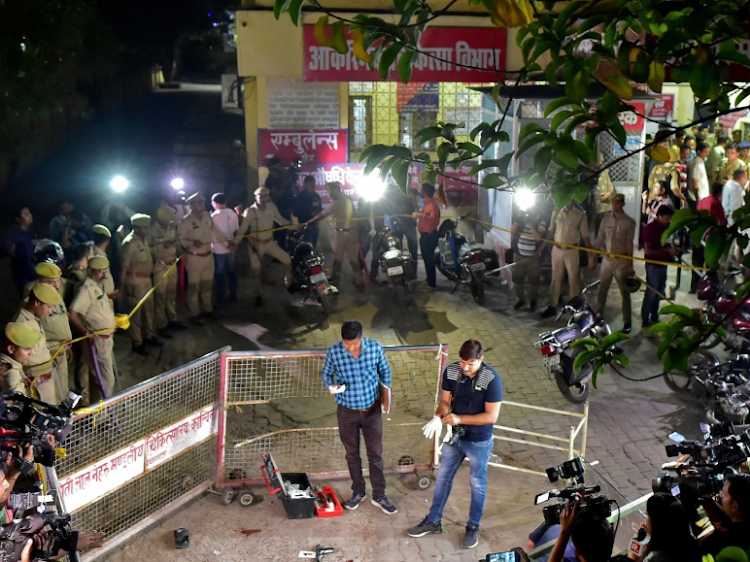 Forensic officials examine the spot where Atiq Ahmed, a former lawmaker in India's parliament, accused in several criminal cases, and his brother Ashraf Ahmed were shot dead in Prayagraj, India, April 15, 2023.