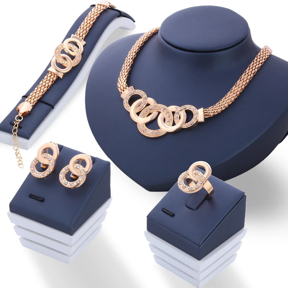 Retro Overdreven Vijf-Ring Sieraden Set Ketting Oorstuds Armband Ring. Maak een statement met deze unieke en opvallende sieradenset voor de moderne vrouw.