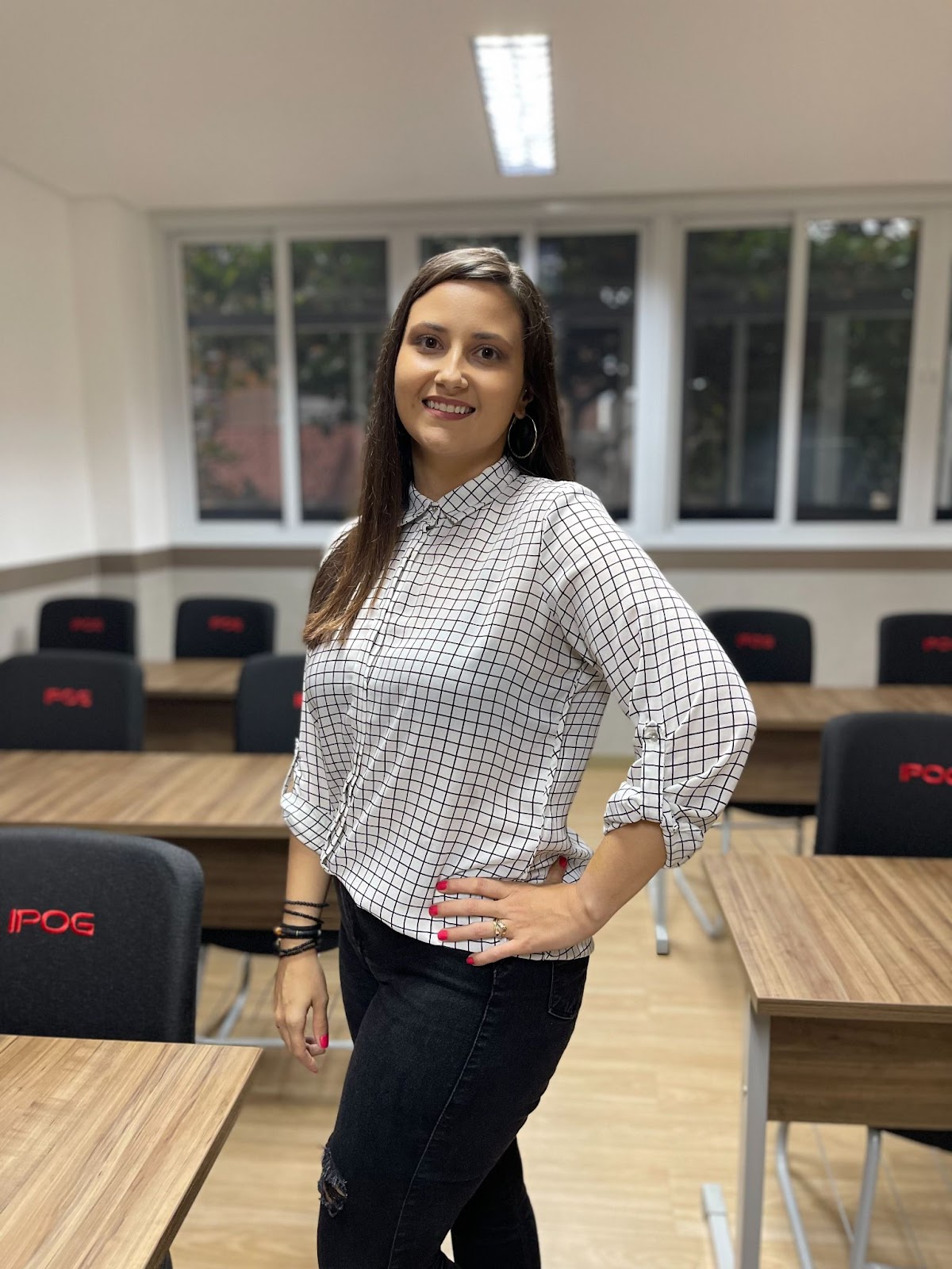 Imagem de Carinna Alves, ex-aluna da pós-graduação em Neurociência, em uma sala do IPOG.