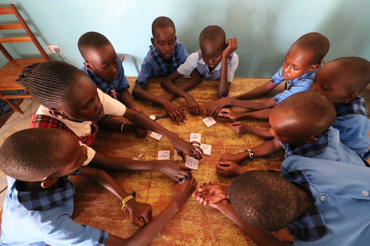 Learners jog their minds using a magic square during the maths session.