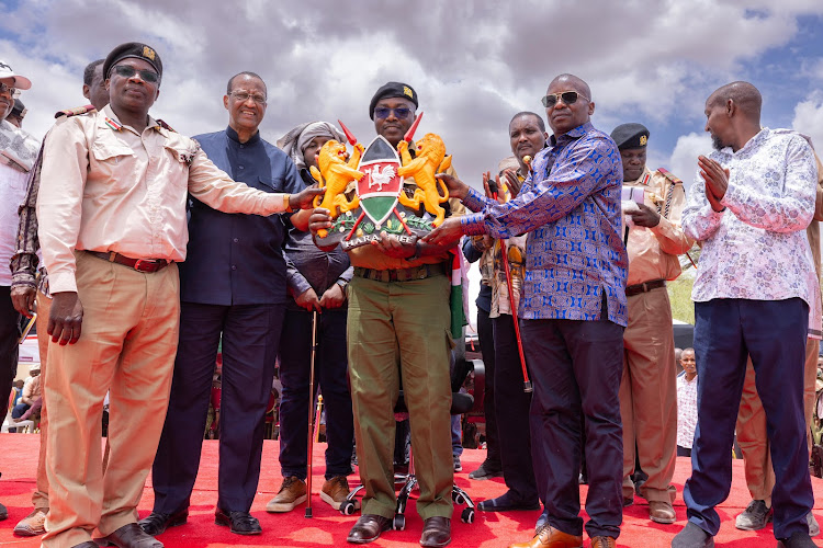 Interior CS Kithure Kindiki handing over instruments of powers to the new dputy County Commissioner’s (DCC) Kennedy Lwenyi at Shanta Abaq Town in Lagdera Constituency in Garissa on March 5, 2024