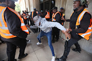 Security guards and protesting students clash outside the University of the Witwatersrand's Great Hall in Johannesburg on Thursday.