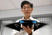 FIN-ISHED PRODUCT   Chew Chee Meng  of the National University of Singapore shows the aquatic robot manta ray MantaDroid Picture: Edgar Su/Reuters