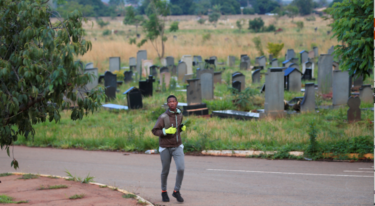 A man runs during an early morning exercise inside Warren Hills cemetery in Harare, Zimbabwe, on November 24, 2022.