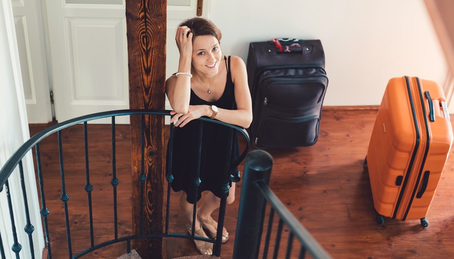 Woman standing at bottom of stairs smiling