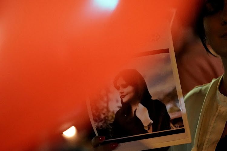 A demonstrator displays an image of Zhina Mahsa Amini, an Iranian Kurdish woman, at a protest and vigil following her death outside the Wilshire Federal Building in Los Angeles, California, US, September 22, 2022.