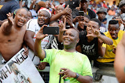 Mamelodi Sundowns coach Pitso Mosimane take selfies with Orlando Pirates supporters during the Absa Premiership match on January 15, 2020.