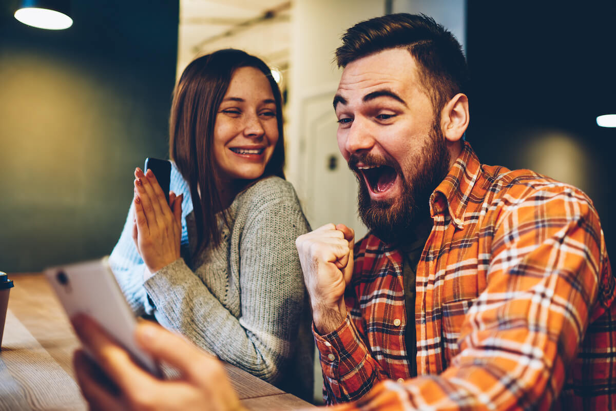 Patient support programs: couple happily looking at a phone