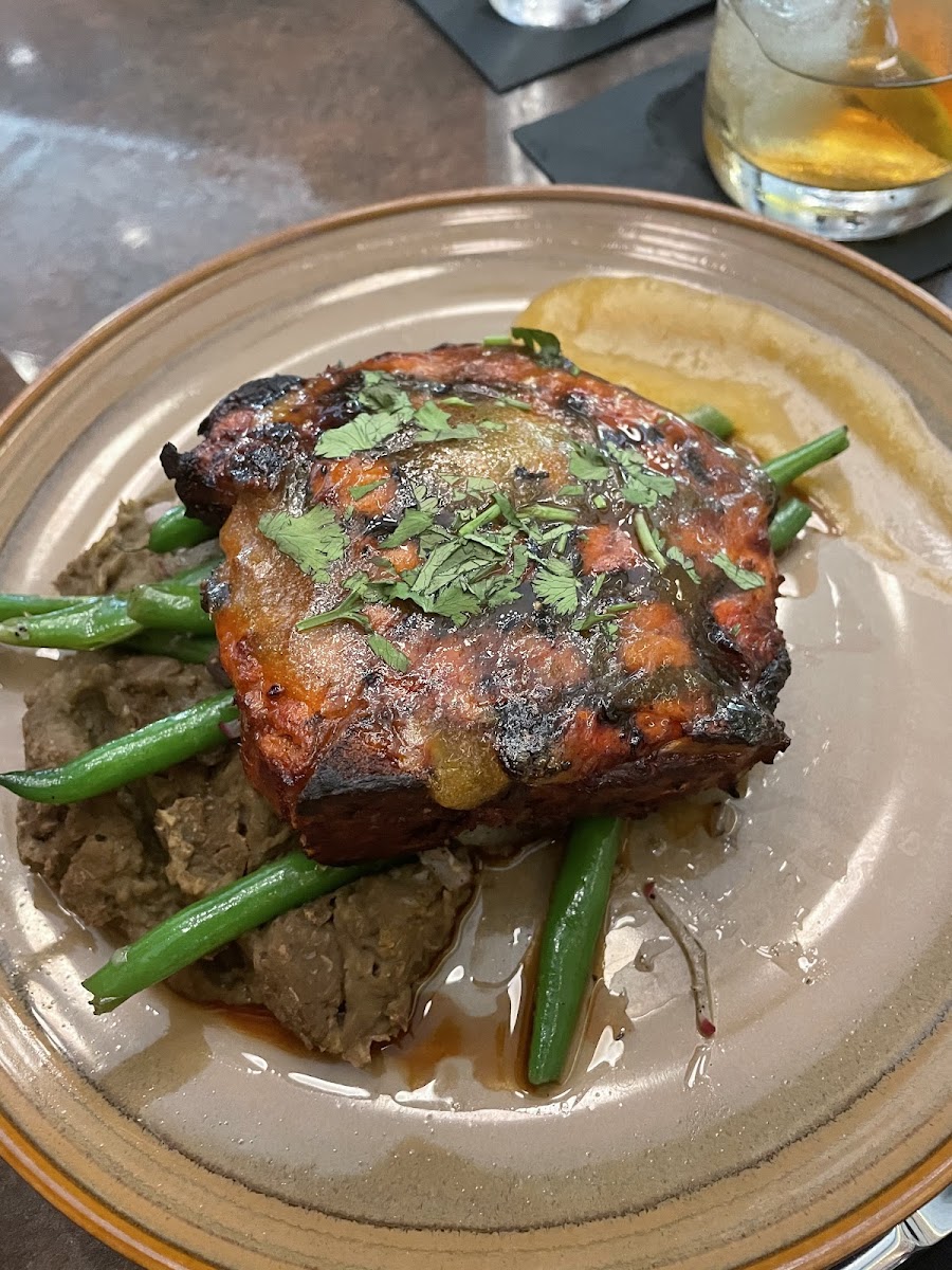 PORK CHOP AL PASTOR 14 oz. pork chop marinated in al pastor seasoning & grilled; served with refried lentils & green beans with radish julienne. Finished with our habanero mango glaze.