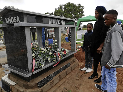 Murder victim Collins Khosa's wife, Nomsa Montsha, and his children Wisani and Gift paying their last respects to him at his grave in Mawa village outside Tzaneen in April.