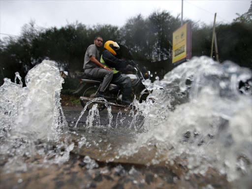 A motorcyclist rides past sewage gushing from a burst line on the Mugoya- Mai Mahiu road in South C after heavy rains yesterday/JACK OWUOR