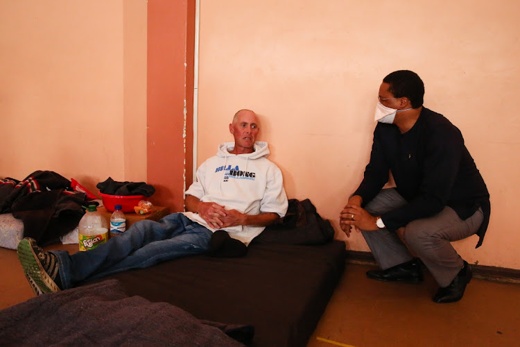 Bhisho legislature deputy speaker Mlibo Qoboshiyane speaks to Brian Heunis, 41, during a visit to the Daku Hall, in Kwazakhele, on Monday. The hall is being used as a temporary shelter for the homeless during the Covid-19 lockdown