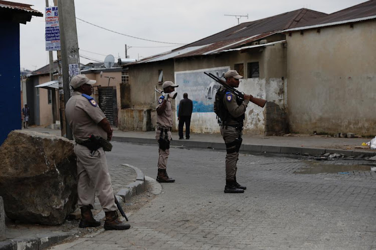 Police officers and members of the SANDF patrol the streets in Alexandra.