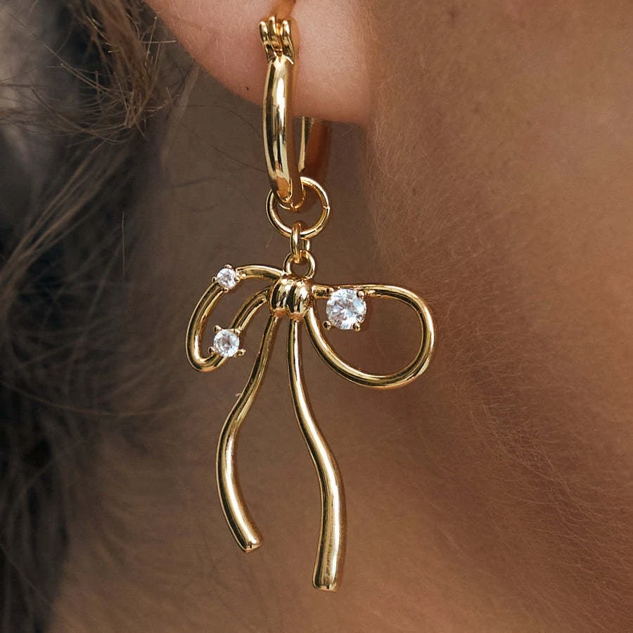 Colar doce com pingente de osso, corrente e laço de zircônia. Banhado a ouro cobre, ideal para um visual delicado e feminino.