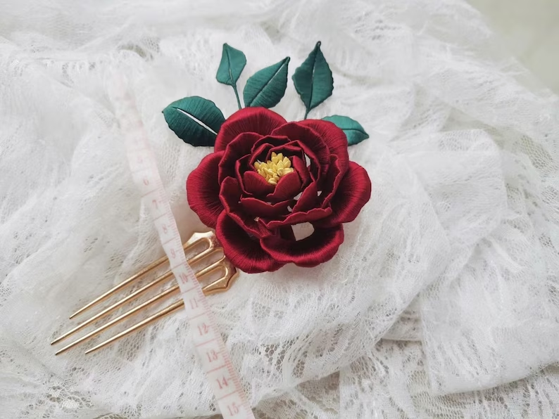 Grampo de cabelo com rosas envoltas, um acessório floral elegante. Ideal para penteados sofisticados e eventos especiais, realça sua beleza natural.