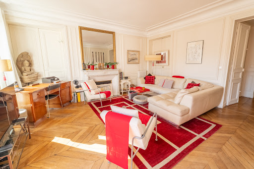 White living room with wood floor and red rug in this luxury apartment / penthouse for sale in Paris 8ème ($1,714,292 - 112 m²)