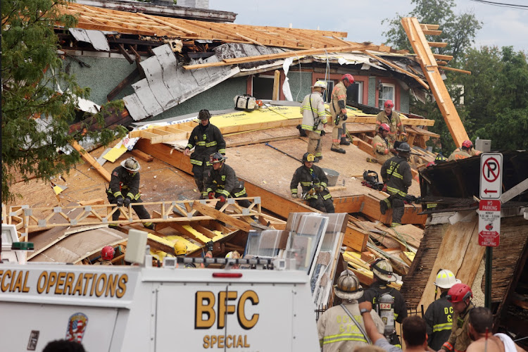 Emergency personnel search the debris for injured workers after a building undergoing construction collapsed on Kennedy Street in Washington, US, July 1, 2021.