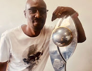 The late Bob Mabena was an ardent fan of Mamelodi Sundowns and is seen here posing with the Nedbank Cup trophy that the team brought to the Power 987 studios. 