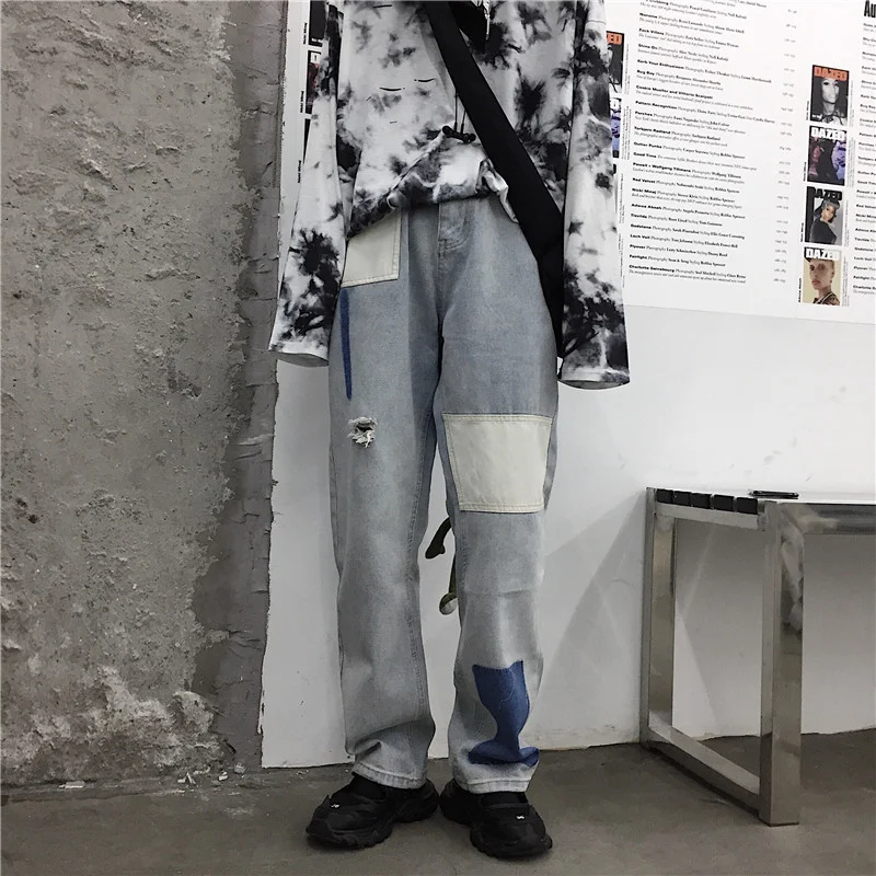 Calça jeans feminina vintage com lavagem clara, corte solto e patches retrô, perfeita para um visual despojado e confortável.