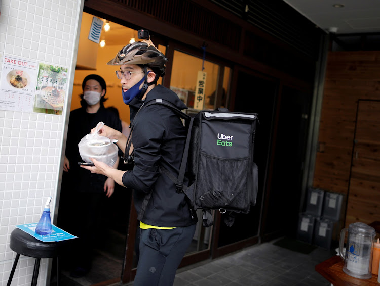 Japan's Olympic fencing medallist Ryo Miyake collects a ramen noodle order from a restaurant as he works his part-time job as Uber Eats delivery person under a nationwide state of emergency as the spread of the coronavirus disease (Covid-19) continues in Tokyo, Japan May 12, 2020.