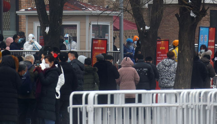 People queue at a nucleic acid test street booth outside a closed loop area designed to prevent the spread of the coronavirus disease (COVID-19) ahead of the Beijing 2022 Winter Olympics in Beijing, China January 23, 2022. REUTERS/Fabrizio Bensch