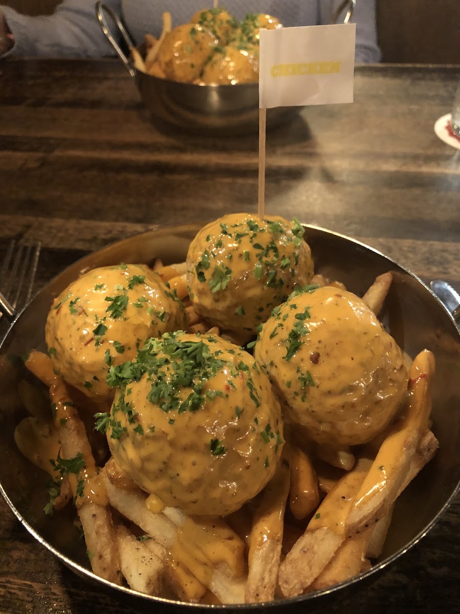 Chicken meatballs with crack sauce over fries.