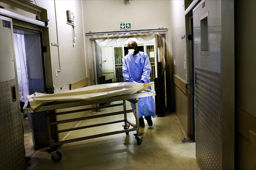 Selby Cindi, a forensic officer from Johannesburg Forensic Pathology Services in Hillbrow, brings in the body of an accident victim.