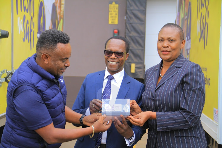 Twiga foods director Yebeltal Gatachew,NCBA ceo John Gachora, and Isuzu ceo Rita Kavashe with a sample of a lorry on Wednesday, September 5, 2022.