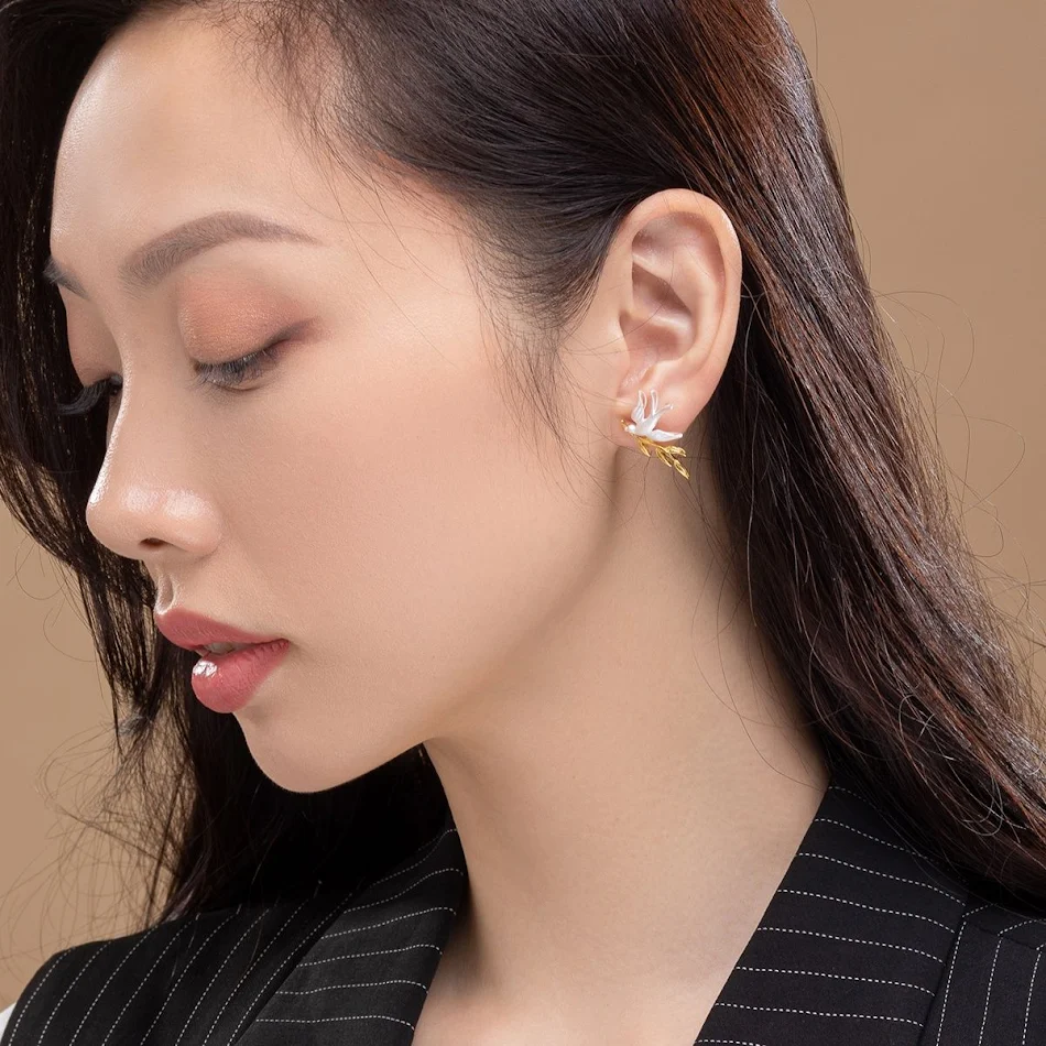 Zilver- en goud vergulde oorhangers met zwaluw en tak. Charmante sieraden voor vrouwen, een perfect cadeau dat geluk en elegantie brengt.