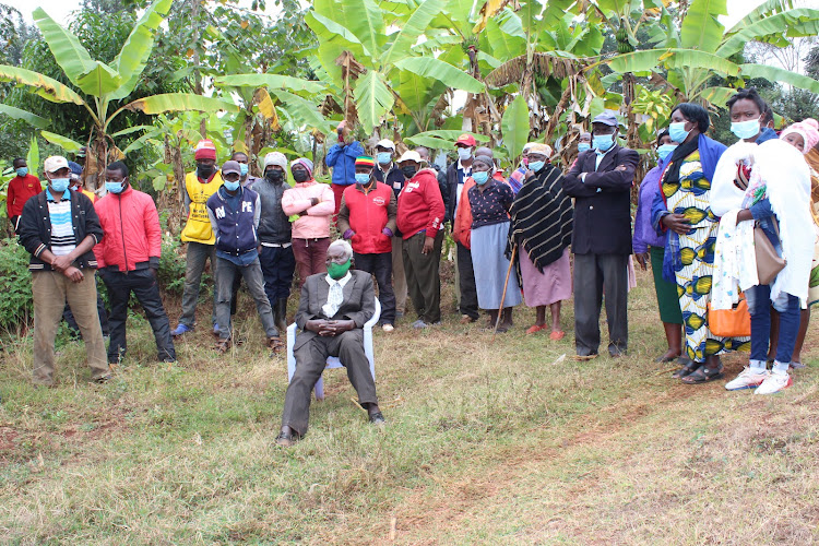 Thomas Mwaga at his home in Ichagaki village, Maragua, with his neighbours.