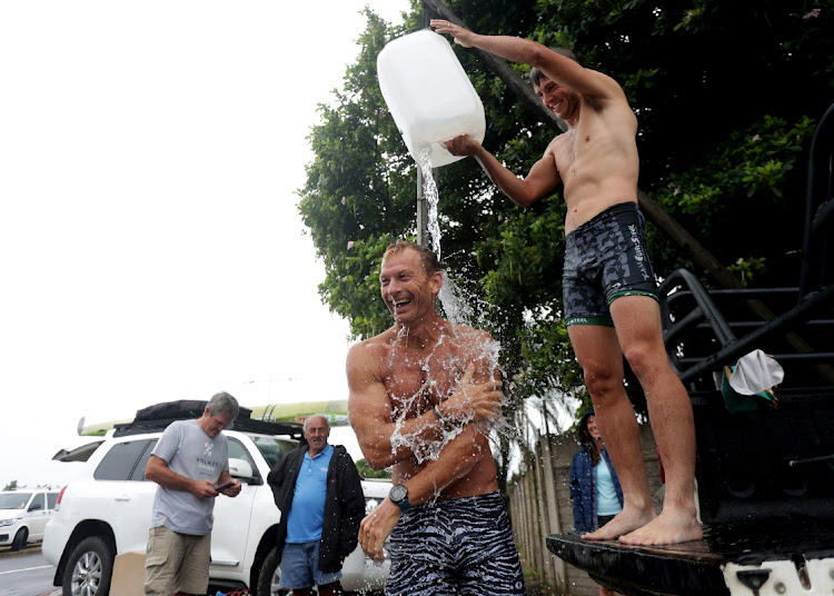 Dirk van Den Berg and Alan Houston washing themselves after a swim in the uMngeni river. The pair took seventh position in the 2024 Dusi canoe marathon