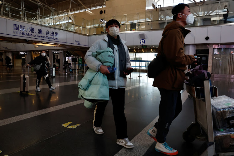 Travellers walk with their luggage on December 27 at Beijing Capital International Airport, China, amid the lifting of restrictions in the country which have worsened the spread of Covid-19. Picture: REUTERS/TINGSHU WANG