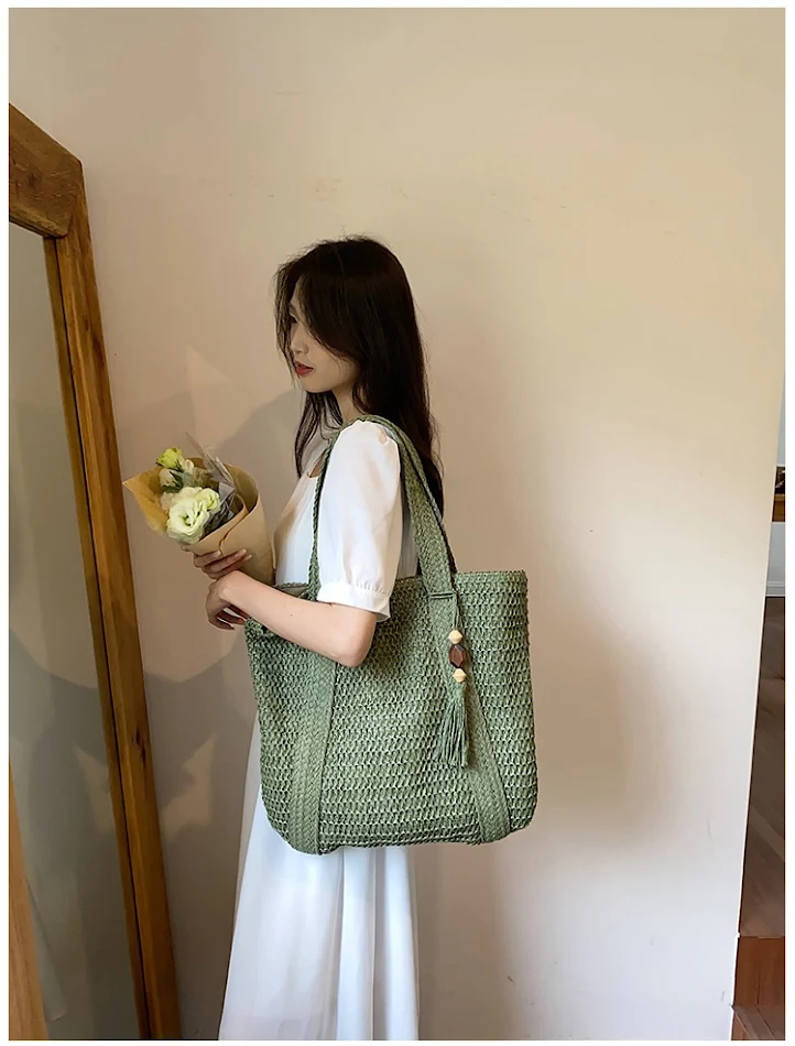 Bolsa feminina casual de praia com alça de ombro, palha e pingente de mogno, perfeita para um look fashion e leve.