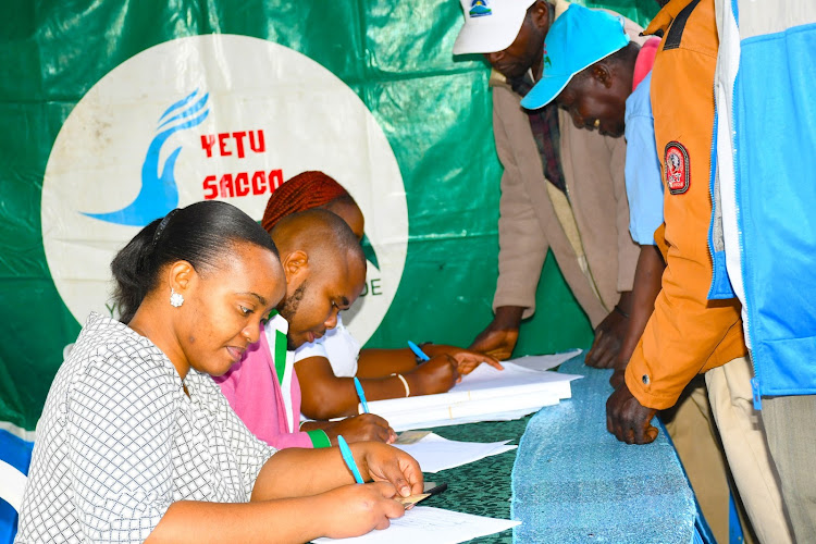 Yetu Sacco staff register members during an AGM meeting at Nkubu