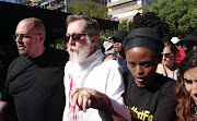 Father Graham Pugin being escorted back into Holy Trinity Catholic Church on 10 October 2016.