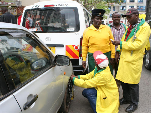 City Hall parking attendants clamp a vehicle.