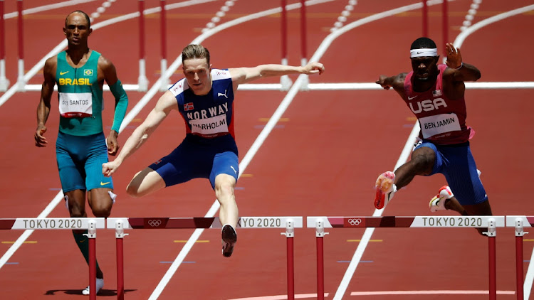 Karsten Warholm of Norway on his way to gold in the 400m hurdles final at Olympic Stadium, Tokyo, August 3, 2021. Alongside of him are silver medallist Rai Benjamin of the United States and bronze medallist Alison Dos Santos of Brazil