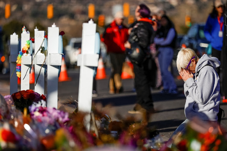 Dallas Dutka, a cousin of victim Daniel Aston, kneels in front of the five crosses displayed at the memorial site for victims after a mass shooting at LGBTQ nightclub Club Q in Colorado Springs, Colorado, US on November 22. There has been another deadly shooting in the US days after the Colorado attack.