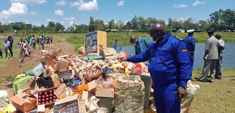 Security officers inspect confiscated beer brands from Uganda.