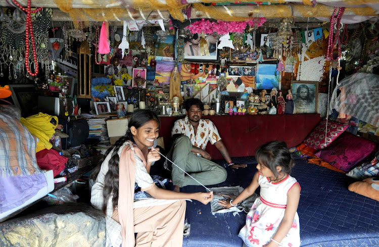 Maleesha Kharwa plays with a relative next to her father Mukesh Kharwa inside their house in Mumbai, India.